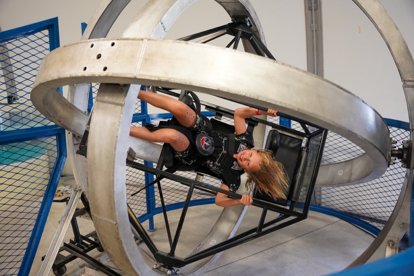 A Space Camp trainee smiling upside down in the multi-axis trainer